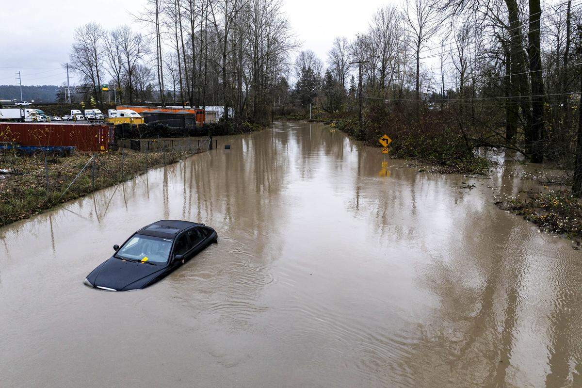 An abandoned car sits in floodwaters near the 12800 block of Houston Road East in Sumner on Wednesday, Dec. 10, 2025. Water from the flooded White River poured over its banks and onto Houston Road on Wednesday afternoon. Heavy rains have caused flooding across numerous rivers basins in Western Washington causing Gov. Bob Ferguson to declare a state of emergency.