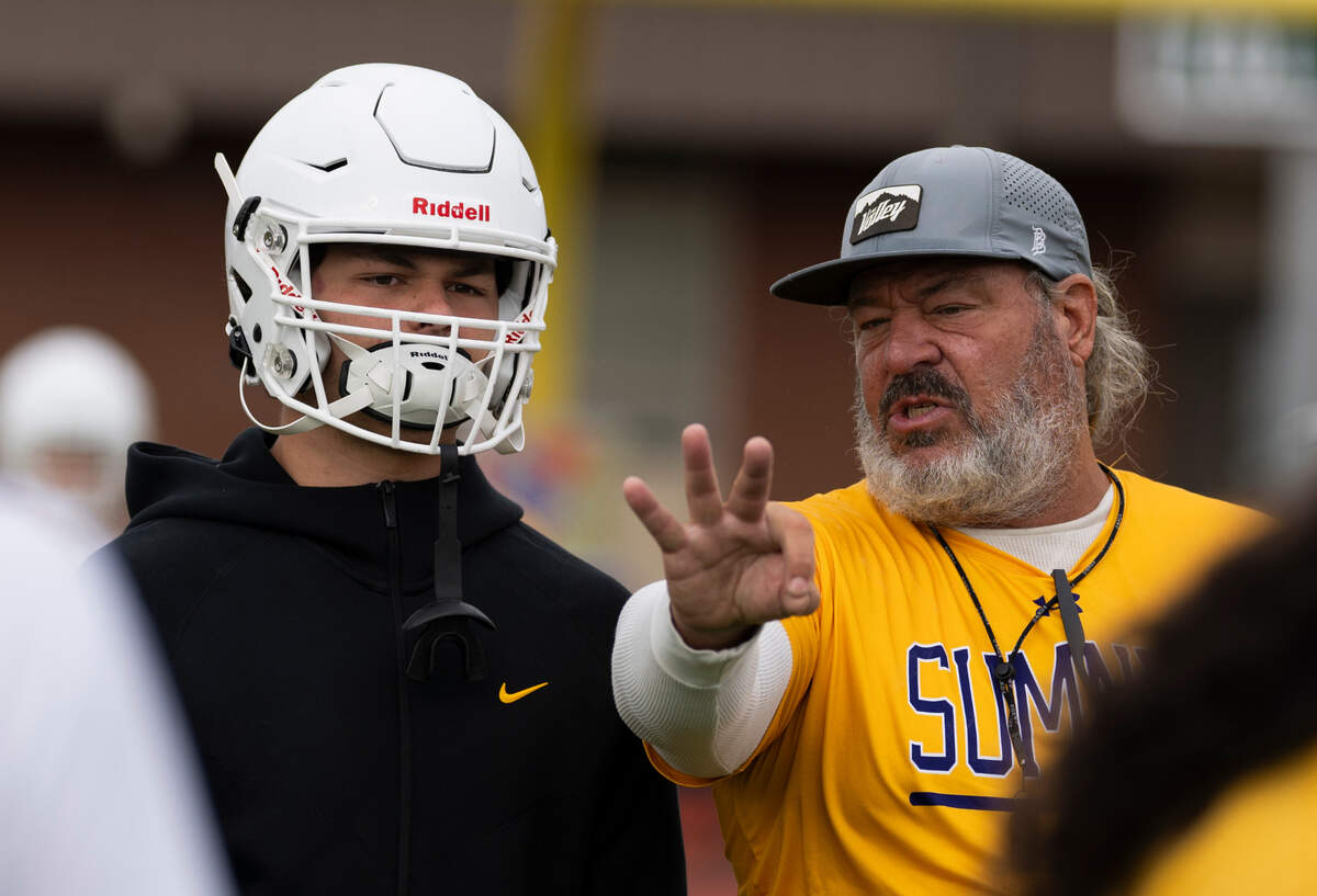 Sumner football coach Keith Ross coaches linebacker Austin Gilvar during a football practice at Sumner High School, on Thursday, Aug. 22, 2024, in Sumner, Wash.