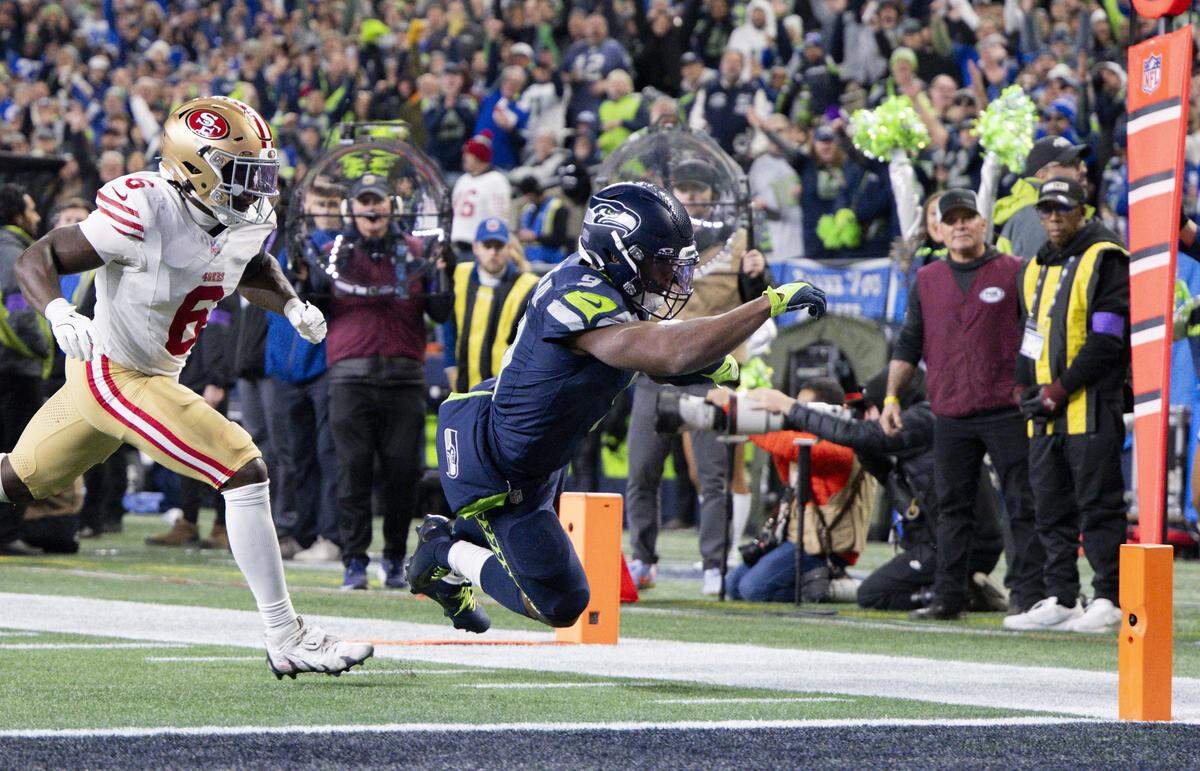 Seattle Seahawks running back Kenneth Walker III (9) dives into the end zone for his second touchdown against the San Francisco 49ers during the third quarter of the NFC Divisional Round game at Lumen Field, on Saturday, Jan. 17, 2026, in Seattle.