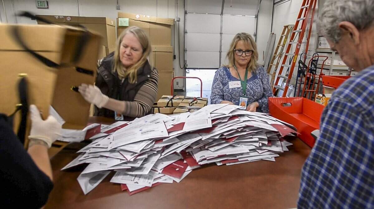 Pierce County Election Center workers bring in ballots from one of more than 40 drop boxes spread around local communities. They’re pouring them from a collection box designed by engineering students at Bates Technical College.