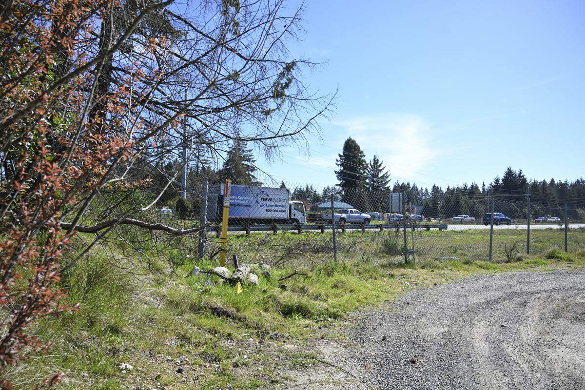 Cars move along state Route 16 behind two parcels of undeveloped property along Hunt Street on Thursday, April 9, 2026, in Gig Harbor, Wash. Gig Harbor Peninsula FISH Food Bank is transferring the land to the city of Gig Harbor for the purpose of affordable housing.