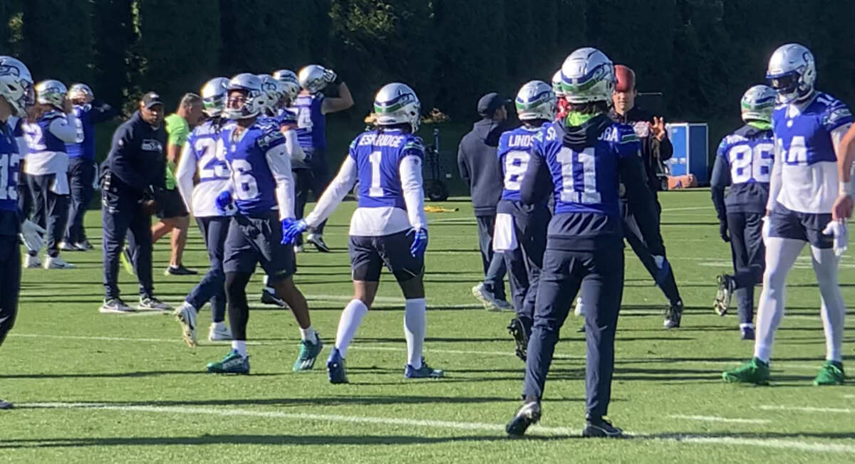 Dee Eskridge (1) greets Tyler Lockett (16) as Jaxon Smith-Njigba (11) and DK Metcalf (14) join them at team headquarters in Renton practicing Friday, Oct. 27, 2023, for the Seahawks’ game against the Cleveland Browns two days later.