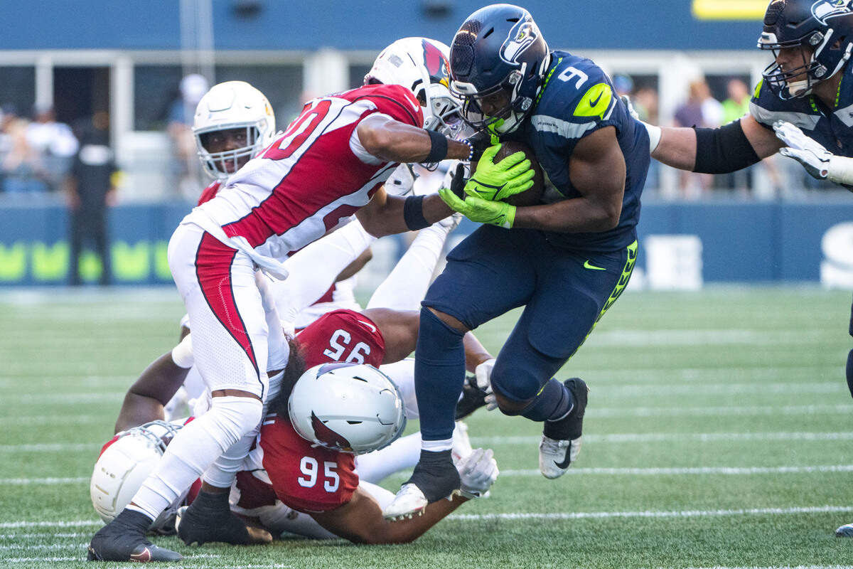 Seattle Seahawks running back Kenneth Walker III (9) breaks through a barrage of tackle attempts by Arizona Cardinals defenders during the third quarter of an NFL game on Sunday, Oct. 16, 2022, at Lumen Field in Seattle.