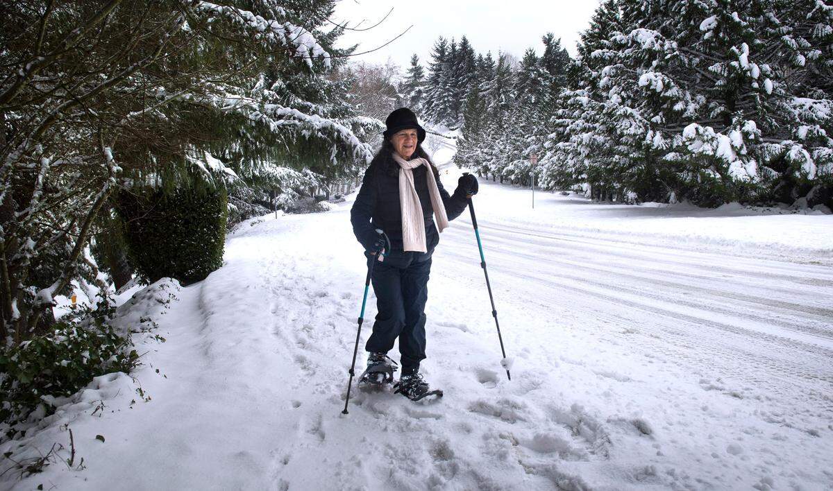 Hilarie Hauptman snowshoes up Vista Place on Tumwater HIll in Tumwater, Washington, on Thursday, Dec. 30, 2021.
