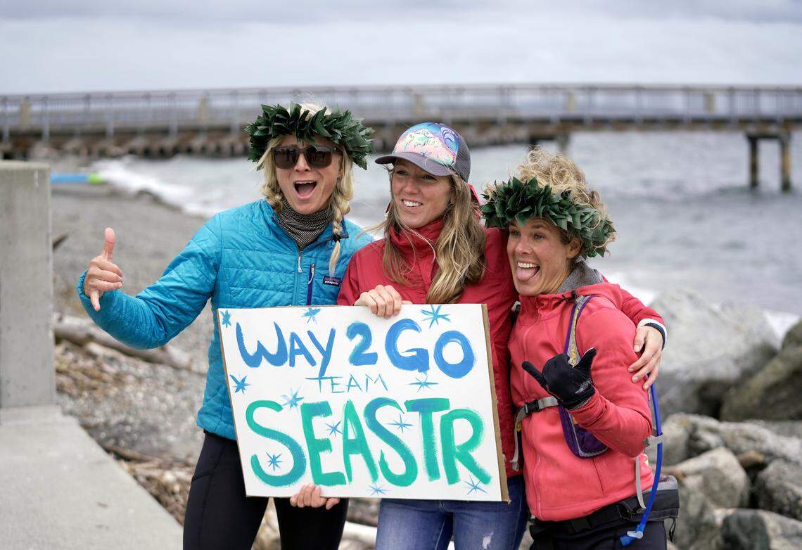 People cheering paddlers on from land.