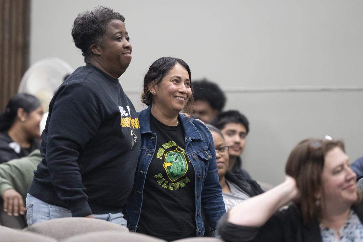 Foss High School athletic director Shiante Reed, left, and Foss High School nurse Ada Gutierrez walk side by side on Thursday, May 14, 2026, before being recognized for intervening during an aggravated assault at Foss High School in April. Reed received a Medal of Courage and Gutierrez received a Certificate of Merit at the Tacoma Public Schools Professional Development Center in Tacoma, Wash.
