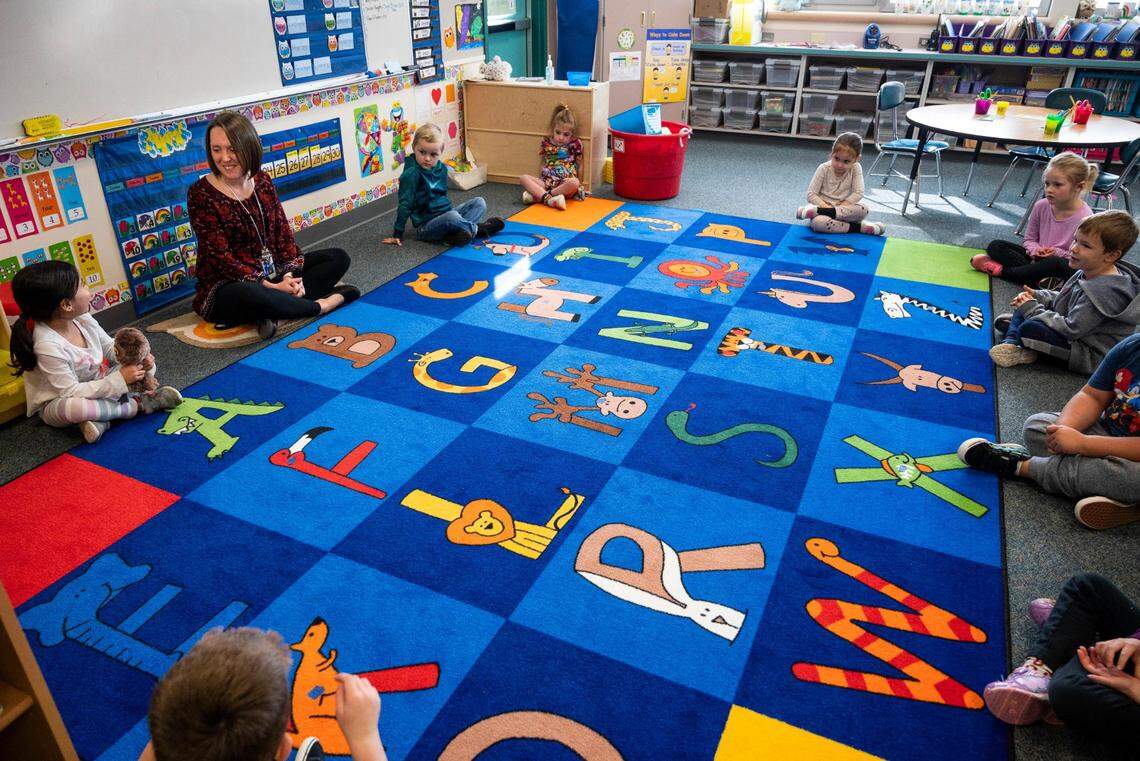 Michelle Cook, left, talks to her transitional kindergarten students during a class activity at Harbor Heights Elementary School on Thursday, April 28, 2022 in Wollochet, Wash. Cook teaches a new six-month transitional kindergarten program to get kids prepared for kindergarten that was started this year by the Peninsula School District.