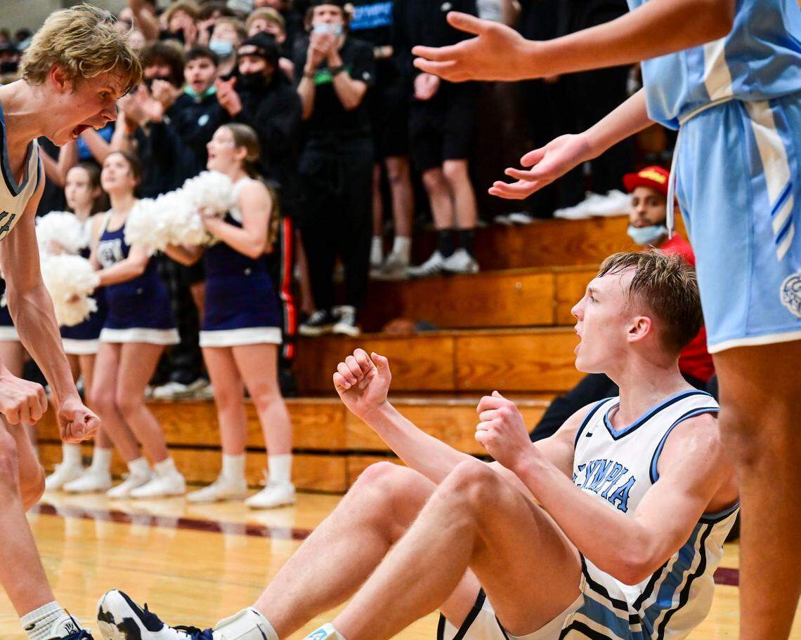 Olympia guard Drew Carlson (left) comes over to celebrate with guard Parker Gerrits (22) after Gerrits fade-away jumper falls through the net while he was getting fouled during the third quarter of a 4A South Puget Sound League tournament championship game against Curtis on Saturday, Feb. 5, 2022, at Bethel High School in Spanaway, Wash.