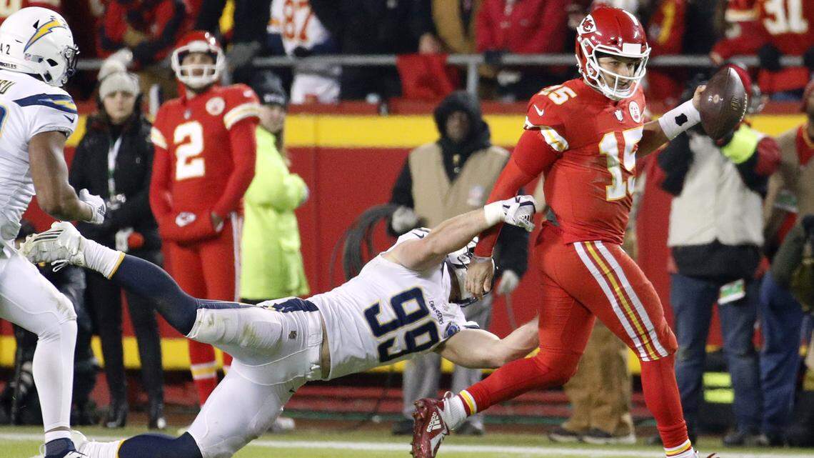 Kansas City Chiefs quarterback Patrick Mahomes (15) runs past a tackle attempt by Los Angeles Chargers defensive end Joey Bosa (99) during the second half of an NFL football game in Kansas City, Mo., Thursday, Dec. 13, 2018. (AP Photo/Charlie Riedel)