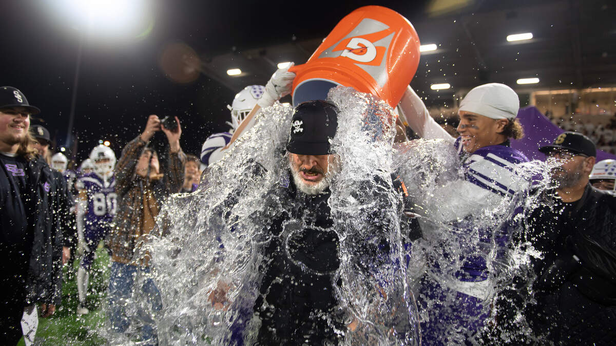 Sumner head coach Keith Ross is drenched by ice water as the Spartans celebrate as time expires in Friday night’s football game against the Graham Kapowsin Eagles at Sunset Chev Stadium in Sumner, Washington, on Nov. 1, 2024. Sumner won the game, 23-11.