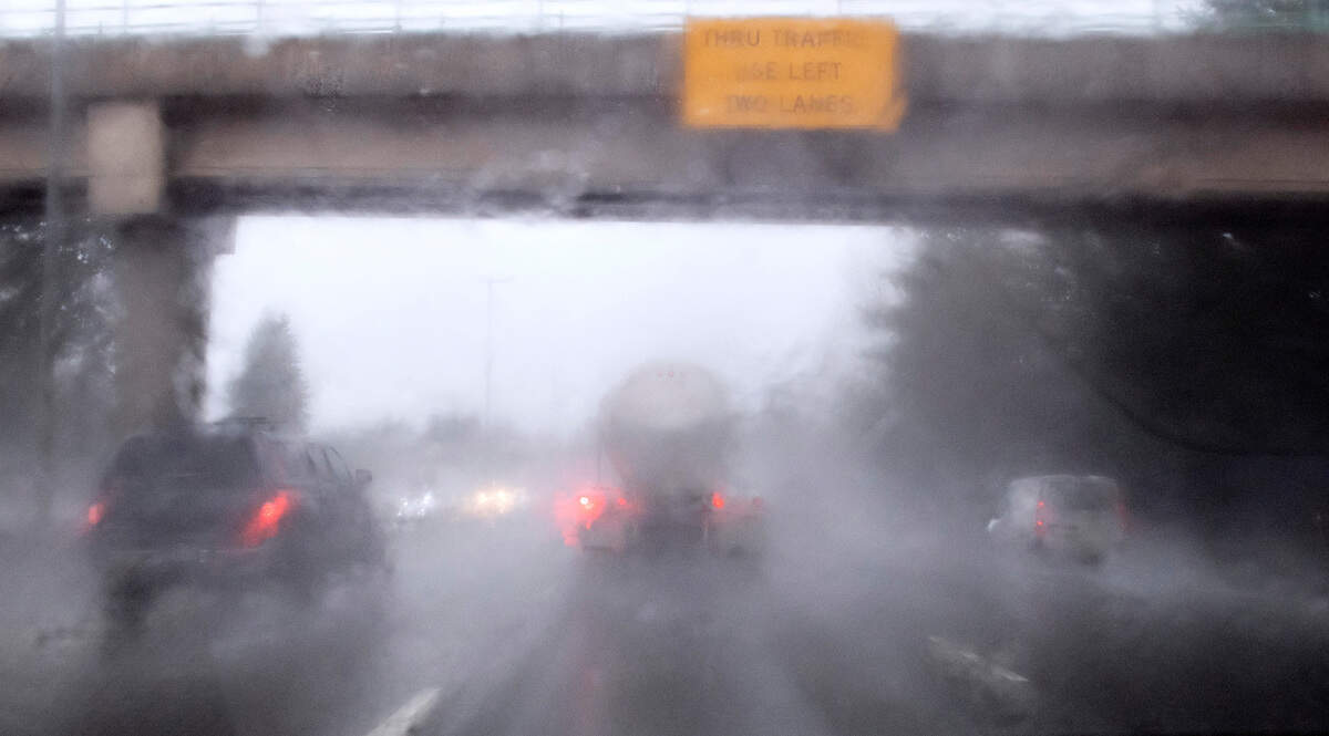 Traffic is obscured by torrential rain as it rolls south on Interstate 5 through Olympia, Washington, on Thursday, Jan. 6, 2022.