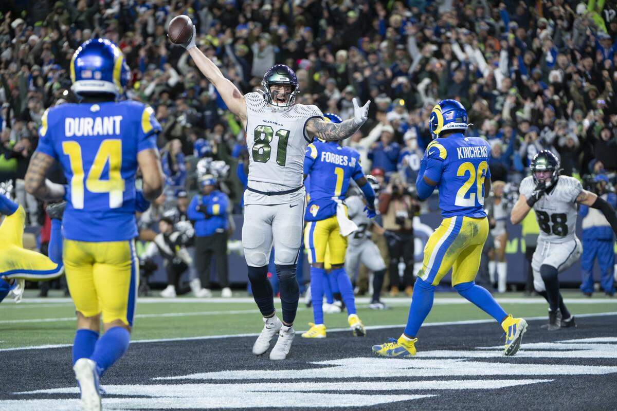Seattle Seahawks tight end Eric Saubert (81) raises his arms in celebration of his two point conversion, winning the game against Los Angeles Rams in overtime at Lumen Field, on Thursday, Dec. 18, 2025, in Seattle.