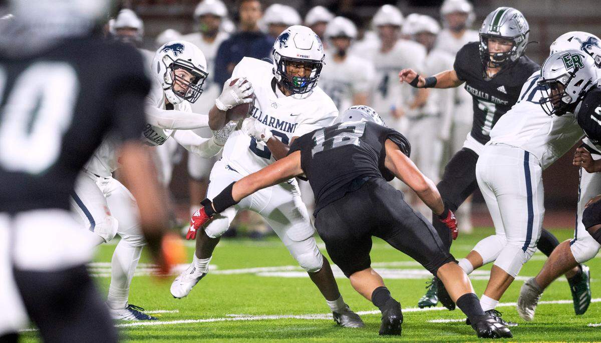 Bellarmine Prep running back Dagim Heiser takes a shot from Emerald Ridge defensive end Jacob Lane during Thursday night’s 4A SPSL football game at Sparks Stadium in Puyallup, Washington, on Sept. 30, 2021.