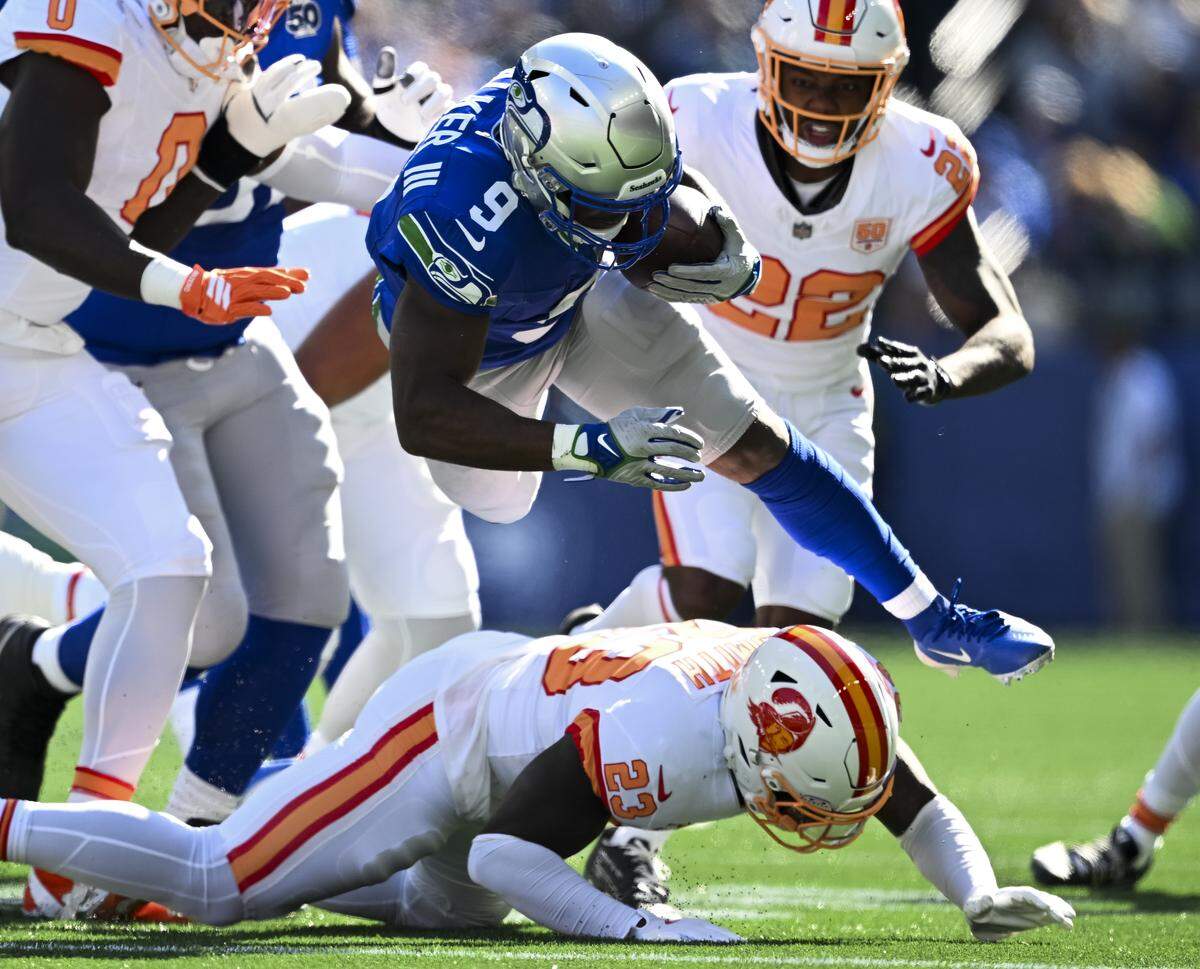 Seattle Seahawks running back Kenneth Walker III (9) gets some air over Tampa Bay Buccaneers safety Tykee Smith (23) during the first quarter of the game at Lumen Field, on Sunday, Oct. 5, 2025, in Seattle. The play was called back on a holding.
