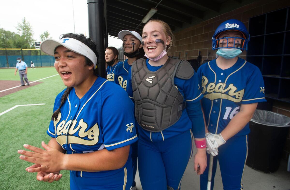 Tahoma infielder Kaiea Higa, catcher Emma Dazell and left fielder Raeden Young keep the spirit up in the Bears dugout during the NPSL softball championship game against Auburn Riverside on Saturday, May 22 at Auburn Riverside High School.