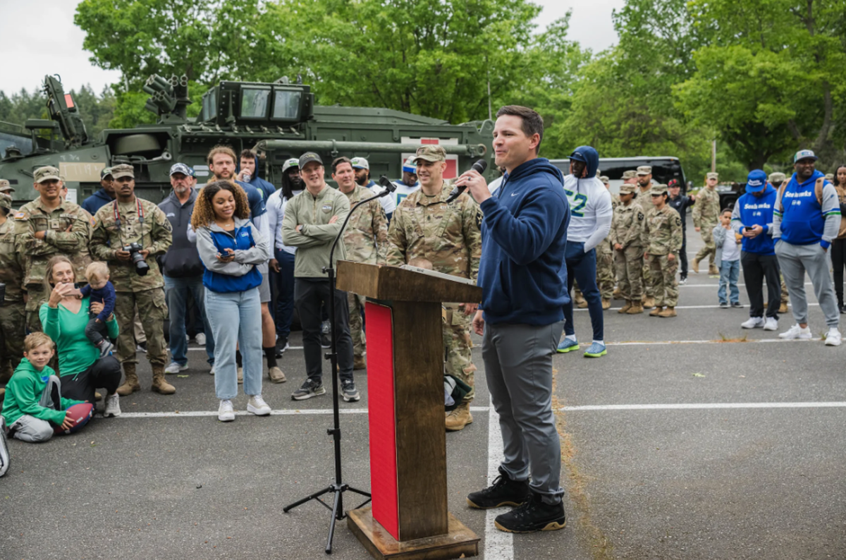 Coach Mike Macdonald talks to soldiers and family members of the 1-2 Stryker Brigade Combat Team at Joint Base Lewis-McChord on the Seahawks’ visit there June 4, 2024.