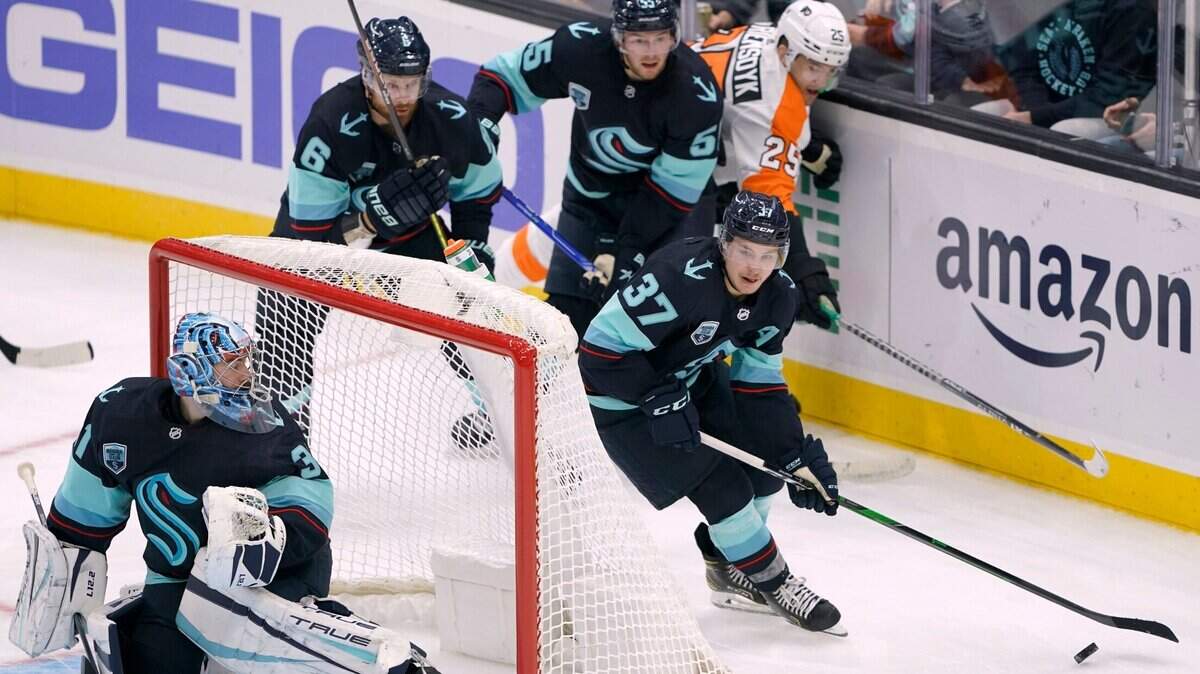Seattle Kraken center Yanni Gourde (37) moves the puck behind goaltender Philipp Grubauer, left, during the second period of the team’s NHL hockey game against the Philadelphia Flyers, Wednesday, Dec. 29, 2021, in Seattle. (AP Photo/Ted S. Warren)
