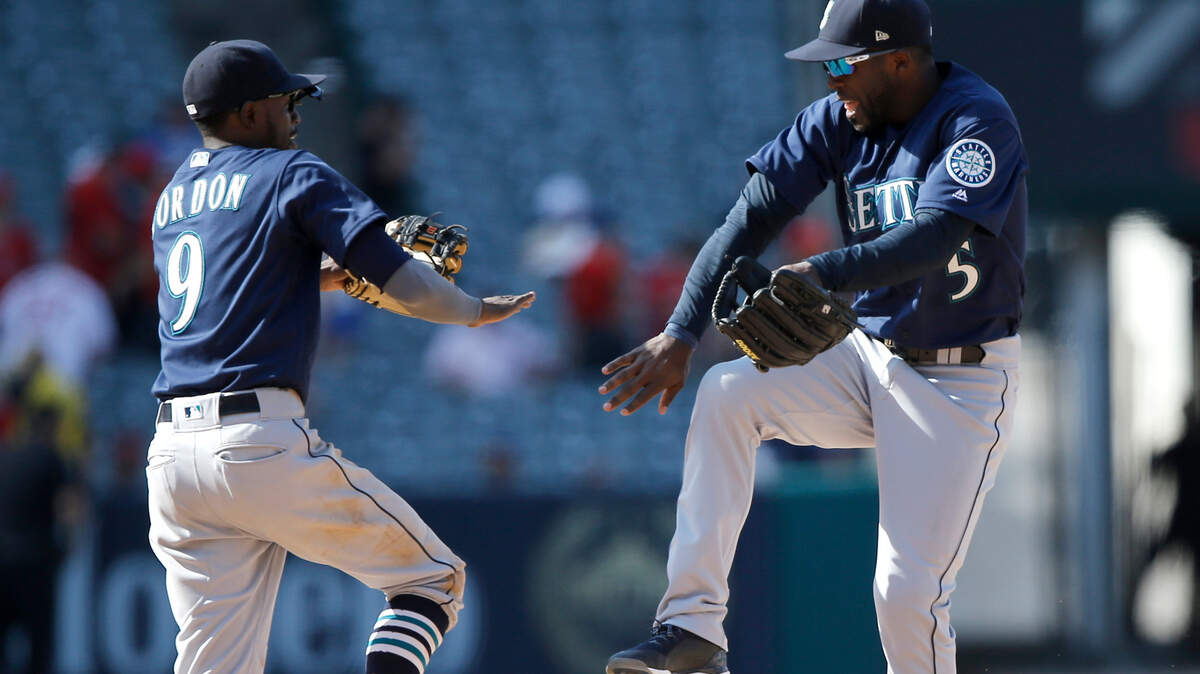 Seattle Mariners second baseman Dee Gordon, left, and center fielder Guillermo Heredia celebrate after they defeated the Los Angeles Angels in a baseball game in Anaheim, Calif., Sunday, July 29, 2018. (AP Photo/Alex Gallardo)