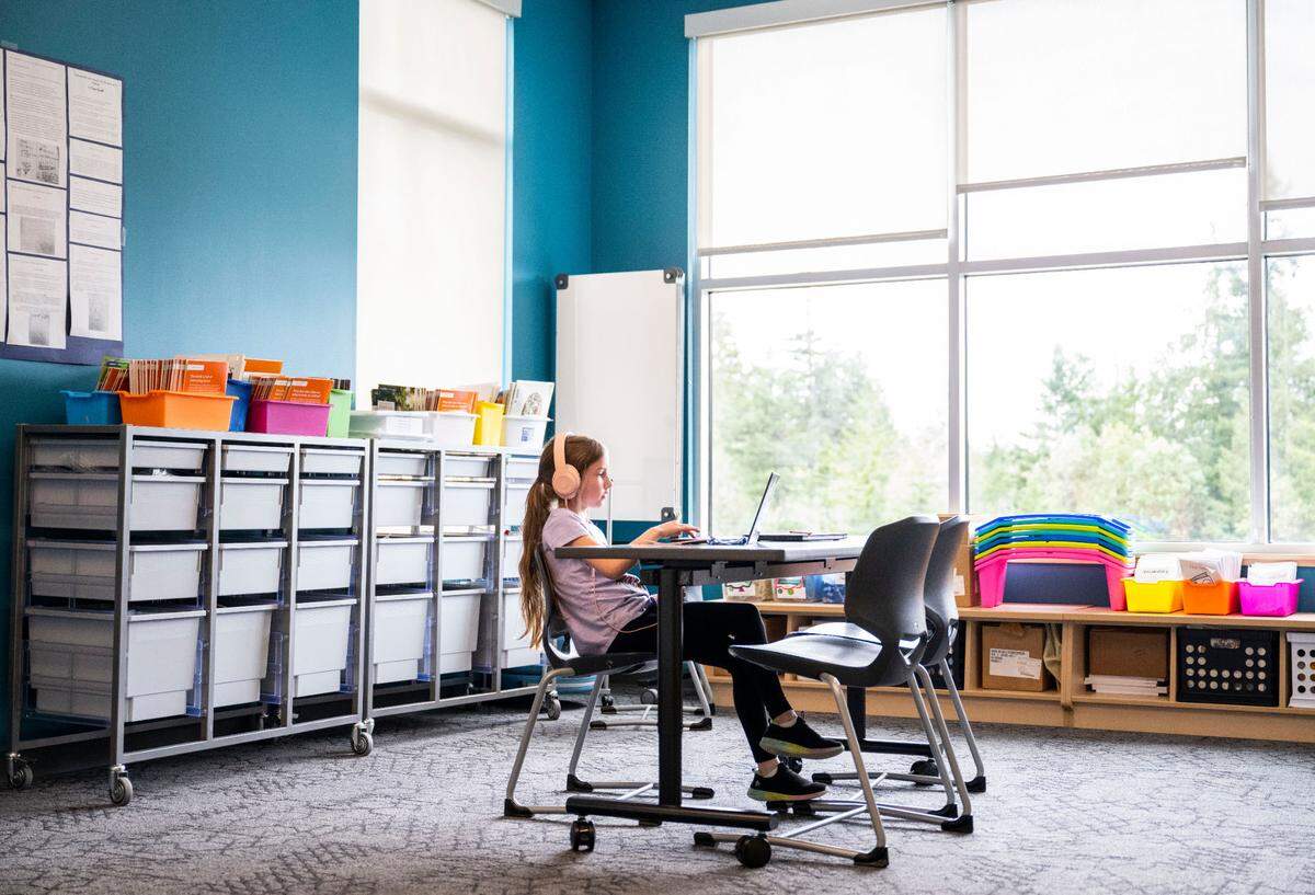 A Pioneer Elementary School student works independently on their laptop in a “flex space” area, where students are able to work in groups or alone to finish projects and homework, at the school in Gig Harbor, Wash. on May 1, 2023.