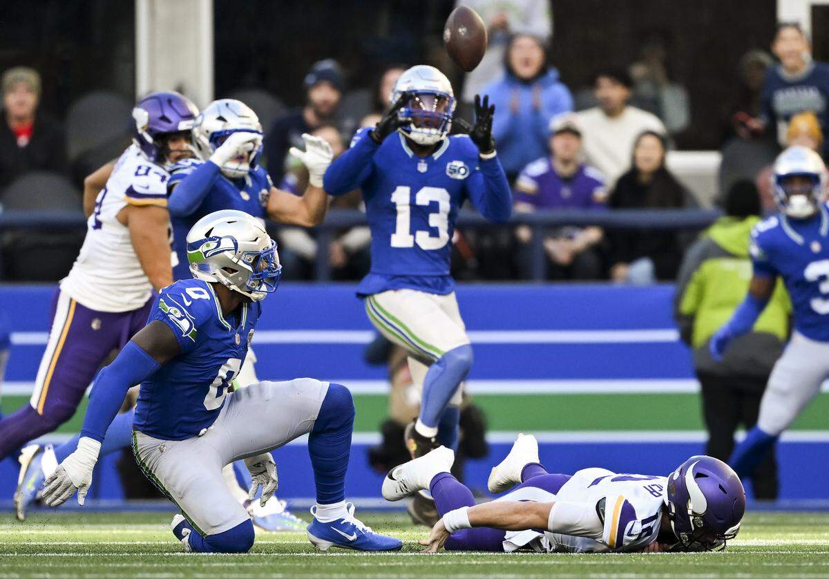 Minnesota Vikings quarterback Max Brosmer (12) hits the ground as Seattle Seahawks linebacker Ernest Jones IV (13) intercepts the ball during the second quarter of the game at Lumen Field, on Sunday, Nov. 30, 2025, in Seattle.