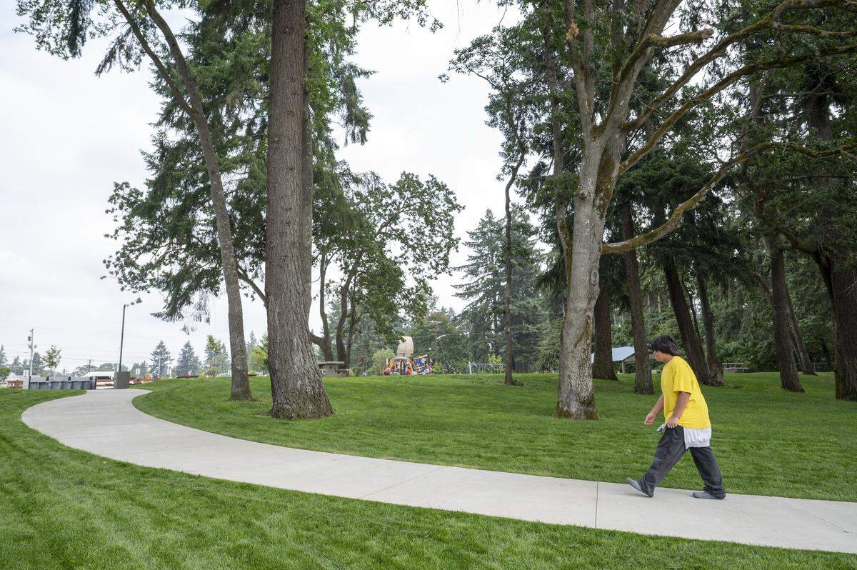 People walk between American Lake Park and the beach on Monday, Aug. 4, 2025, in Lakewood, Wash. The park saw improvements over the last year, including landscaping and access paths.