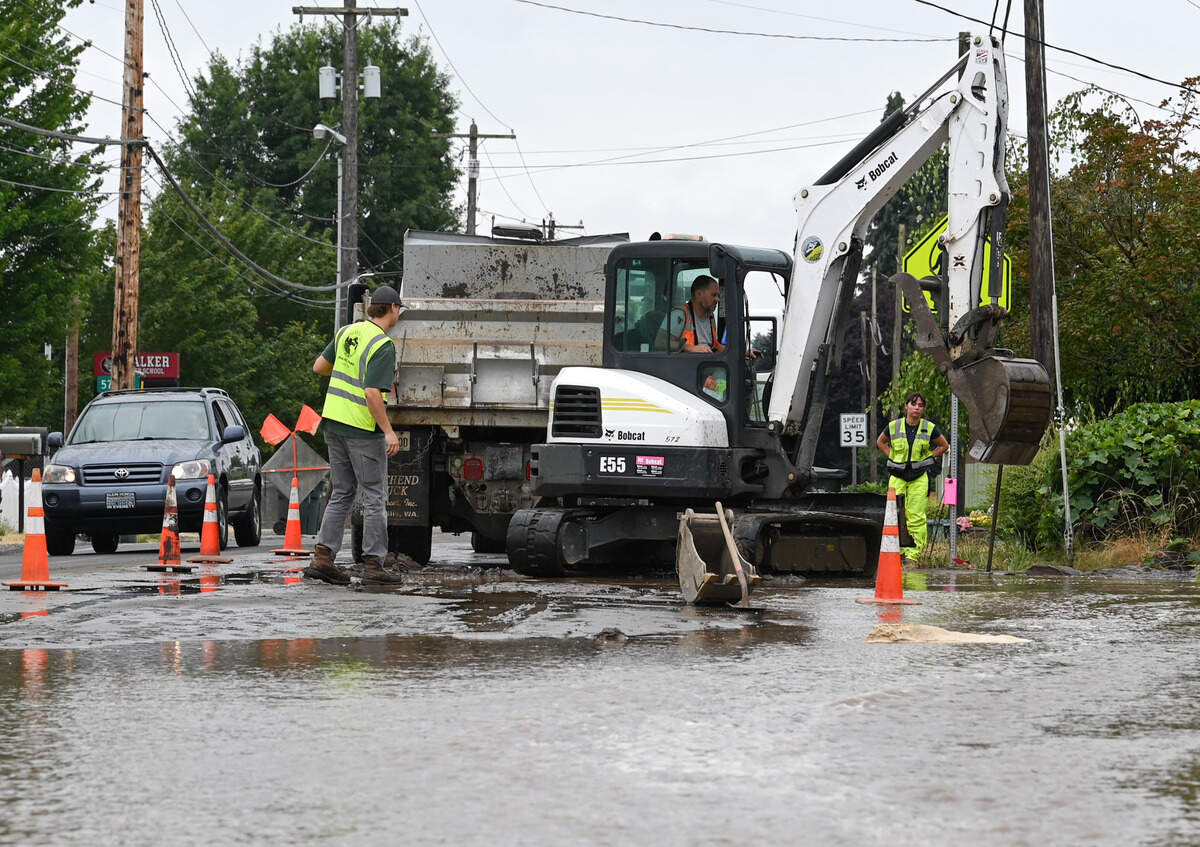 City of Puyallup crews work to clean up a water main break on the corner of Valley Avenue East and Milwaukee Avenue East in Puyallup on July 29.