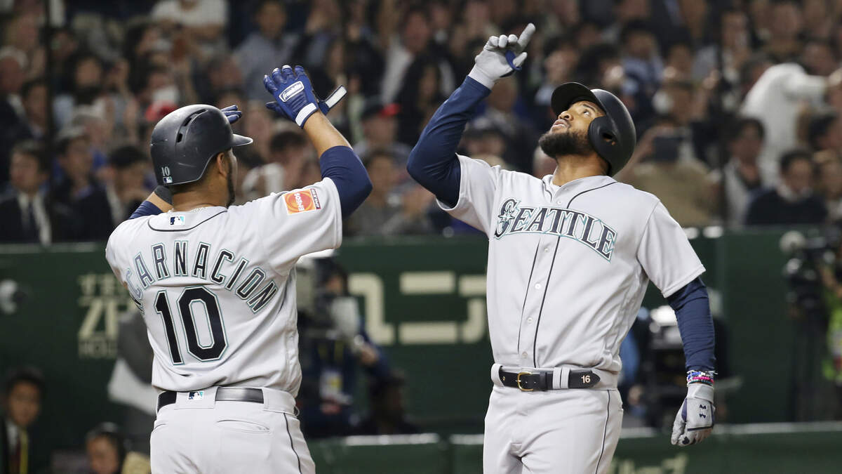 Seattle Mariners’ Domingo Santana, right, celebrates with teammate Edwin Encarnacion after hitting a grand slam against the Oakland Athletics in the third inning of Game 1 of their Major League baseball opening series at Tokyo Dome in Tokyo, Wednesday, March 20, 2019. (AP Photo/Koji Sasahara)