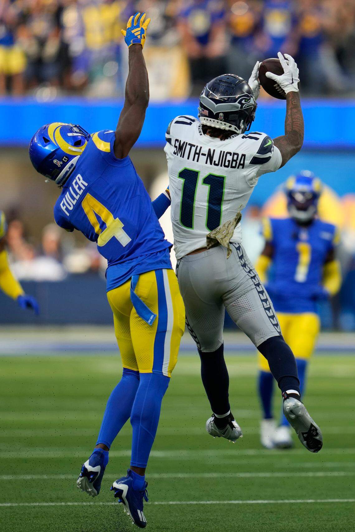 Seattle Seahawks wide receiver Jaxon Smith-Njigba (11) makes a catch in front of Los Angeles Rams safety Jordan Fuller (4) during the first half of an NFL football game Sunday, Nov. 19, 2023, in Inglewood, Calif. (AP Photo/Ashley Landis)