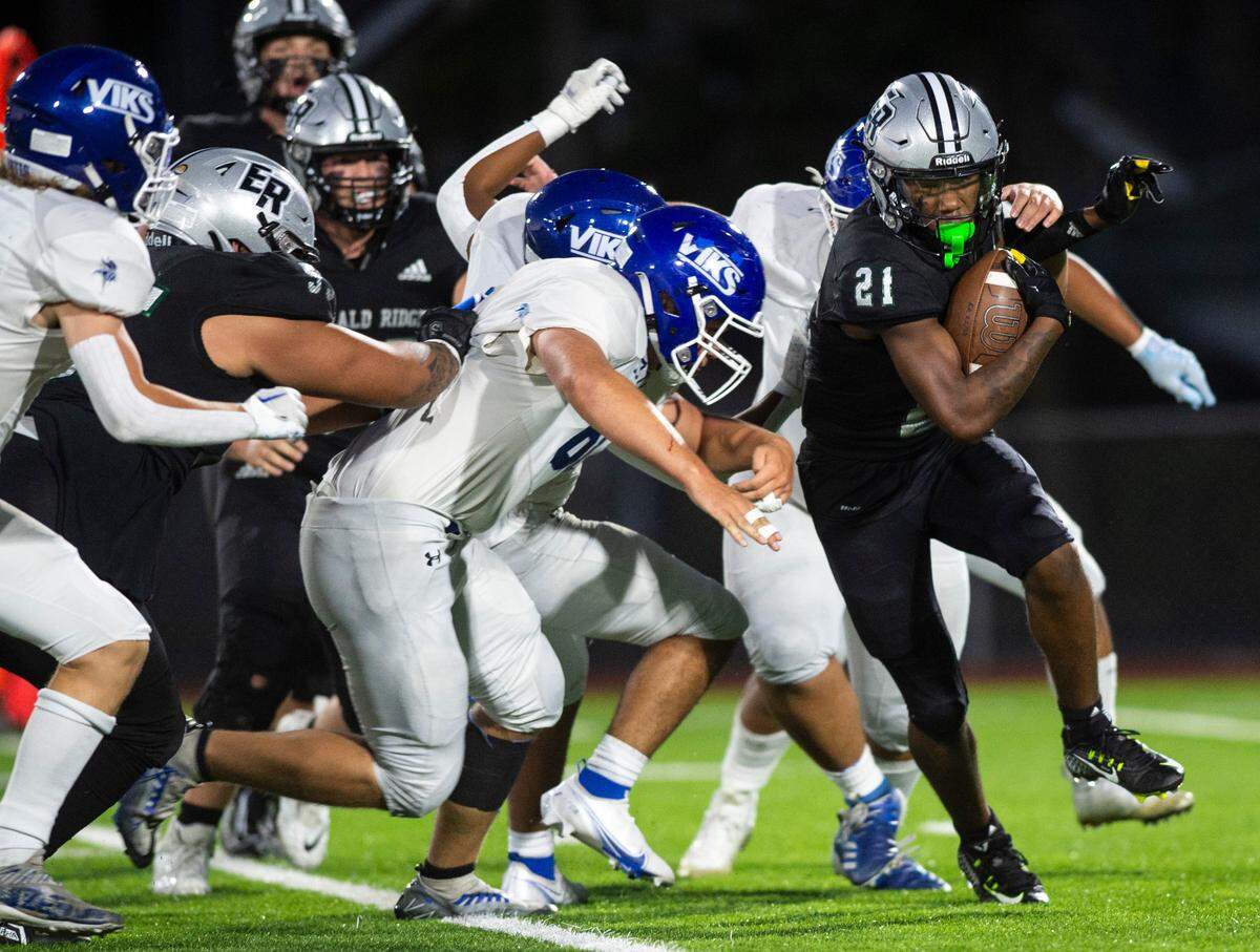Emerald Ridge running back Tayshaun Micks (21) tries to run with the ball as a group of Curtis players tries to tackle him in the first quarter of a game at Sparks Stadium in Puyallup, Wash. on Sept. 22, 2022.