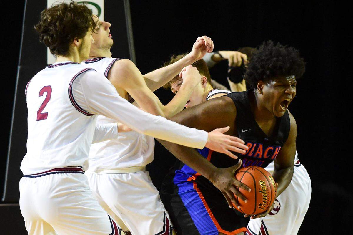 Rainier Beach forward Josh Conerly Jr. (44) looks for an outlet pass after grabbing an defensive rebound between a trio of Mount Spokane players during the third quarter of a Class 3A semifinal state tournament game on Friday, March 4, 2022, at the Tacoma Dome, in Tacoma, Wash.