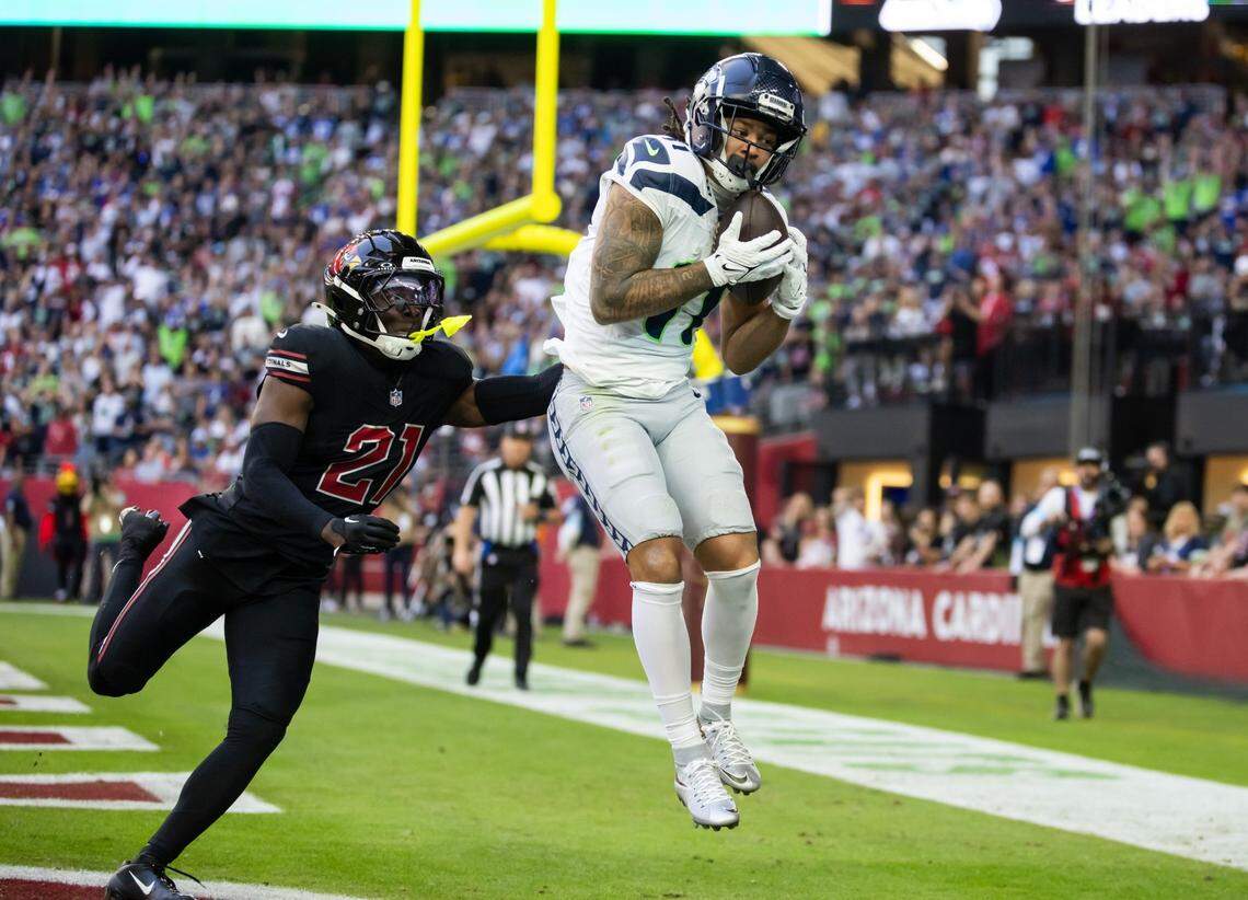 Dec 8, 2024; Glendale, Arizona, USA; Seattle Seahawks wide receiver Jaxon Smith-Njigba (11) catches a touchdown pass against Arizona Cardinals cornerback Garrett Williams (21) in the first half at State Farm Stadium. Mandatory Credit: Mark J. Rebilas-Imagn Images