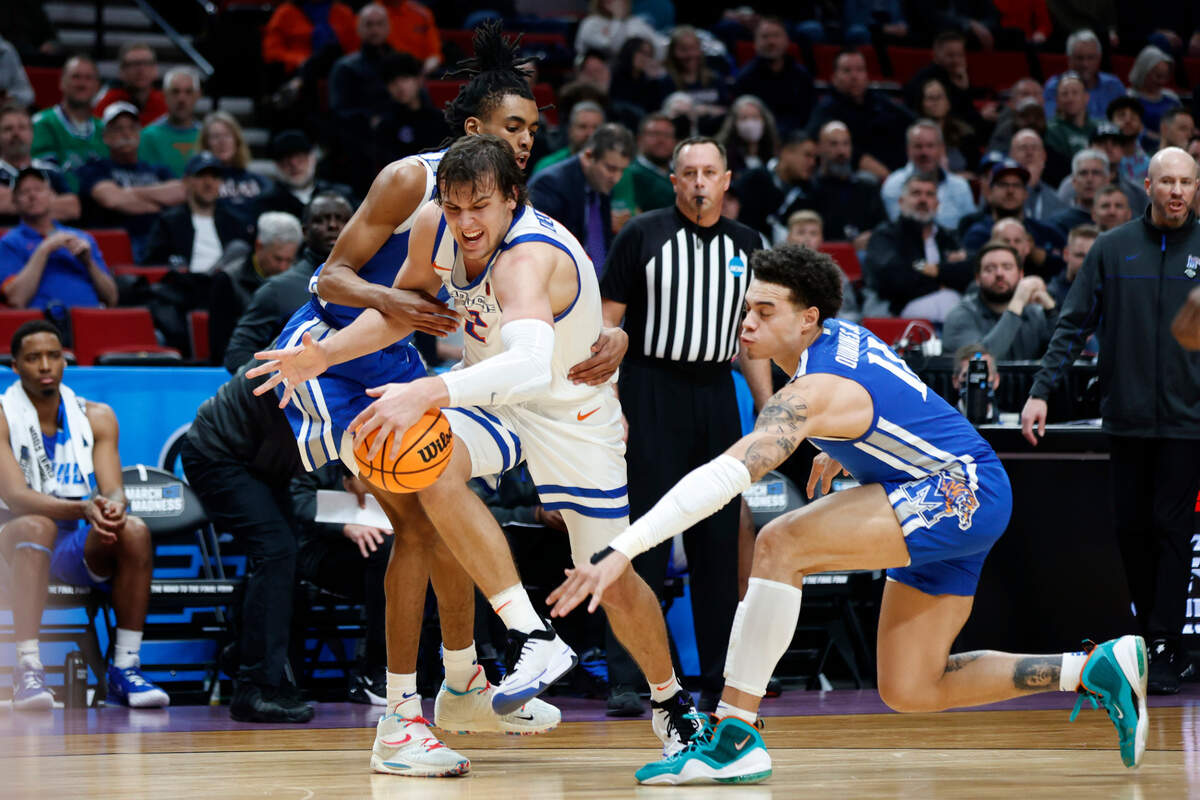 Boise State forward Tyson Degenhart, second from left, is wrapped up by Memphis guard Earl Timberlake, left, as Memphis guard Lester Quinones, right, reaches in, during the first half of a first round NCAA college basketball tournament game, Thursday, March 17, 2022, in Portland, Ore. (AP Photo/Craig Mitchelldyer)