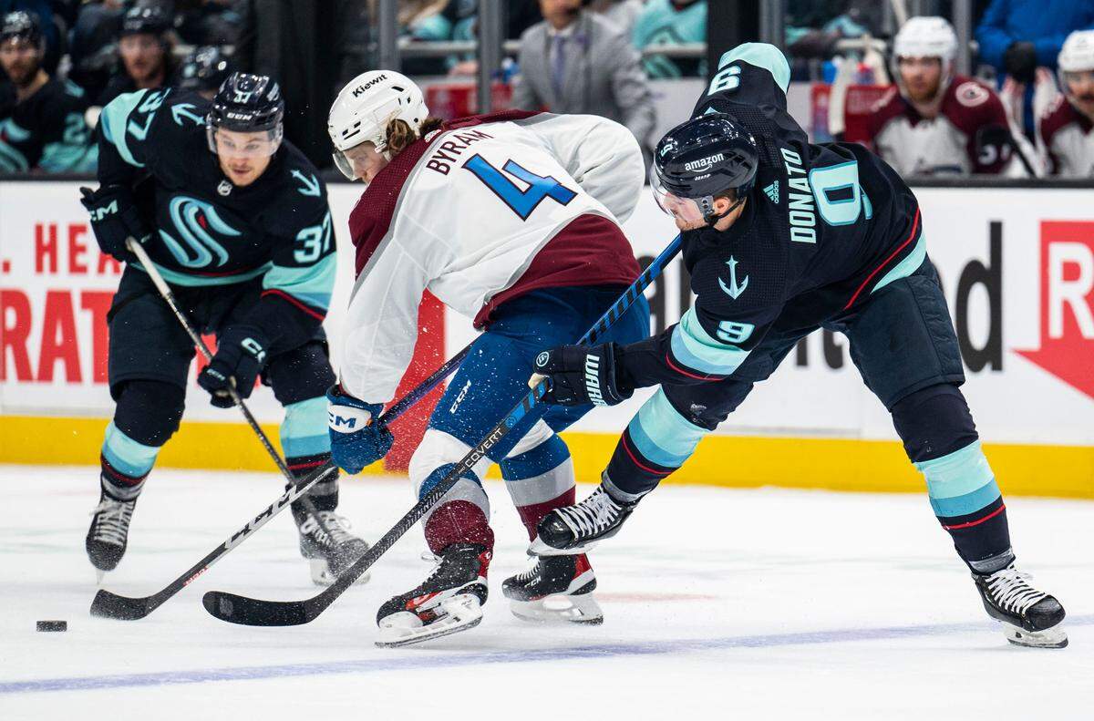 Seattle Kraken center Ryan Donato (9) tries to steal the puck from Colorado Avalanche defenseman Bowen Byram (4) during the first period of a first round 2023 Stanley Cup Playoffs game against the Colorado Avalanches at Climate Pledge Arena in Seattle on Saturday, April 22, 2023.