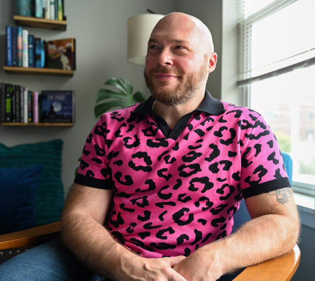 Travis Holp, a local psychic, poses for a portrait in his living room on Friday, Aug. 9, 2024 in Tacoma, WA. Holp became TikTok famous, amassing more than 468k followers, for his tarot reading and call himself the gay uncle of the spirit world.