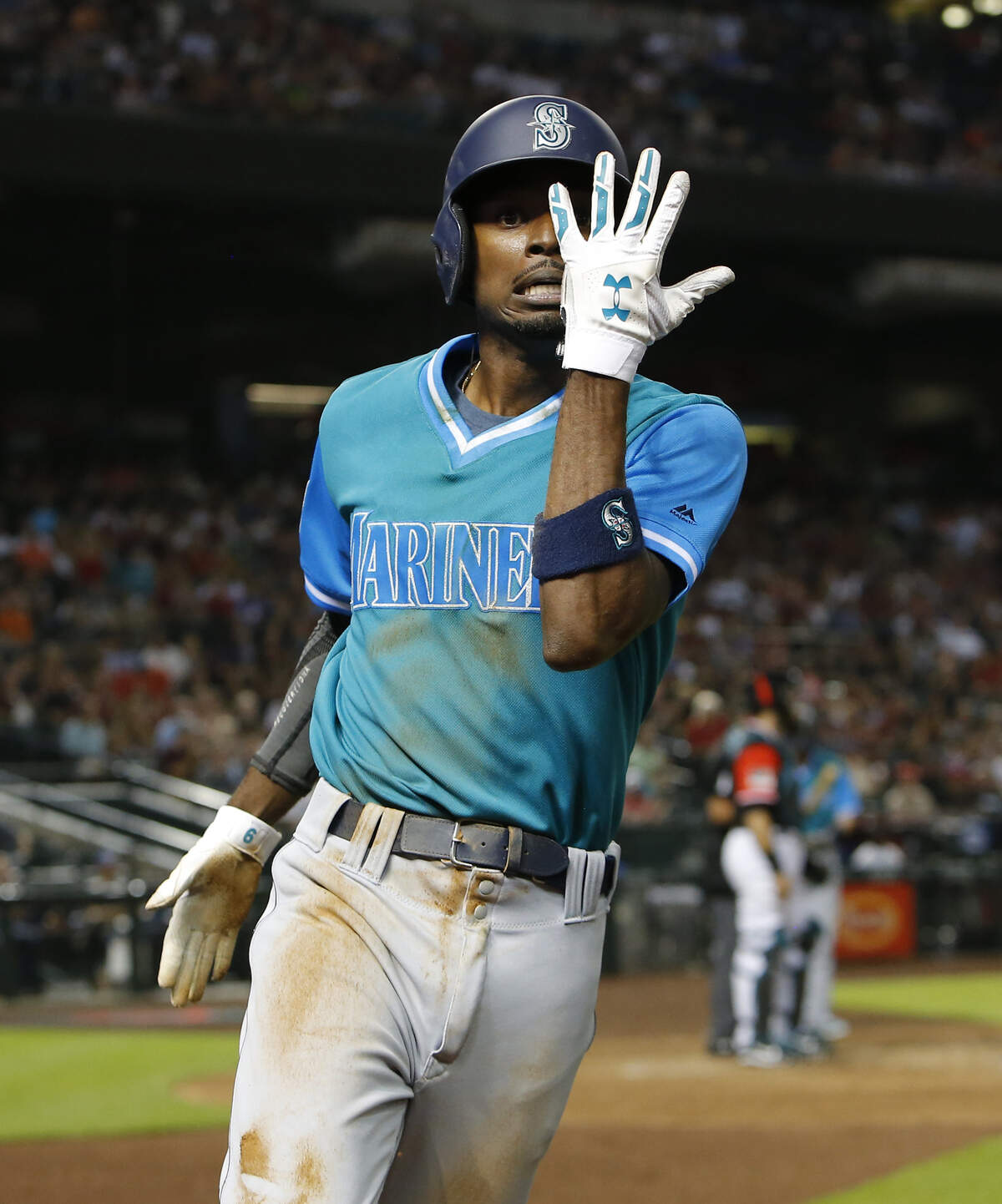 Seattle Mariners Dee Gordon celebrates after scoring on a throwing error by Arizona Diamondbacks pitcher Zack Godley after stealing thirdbase in the third inning during a baseball game, Friday, Aug. 24, 2018, in Phoenix. (AP Photo/Rick Scuteri)