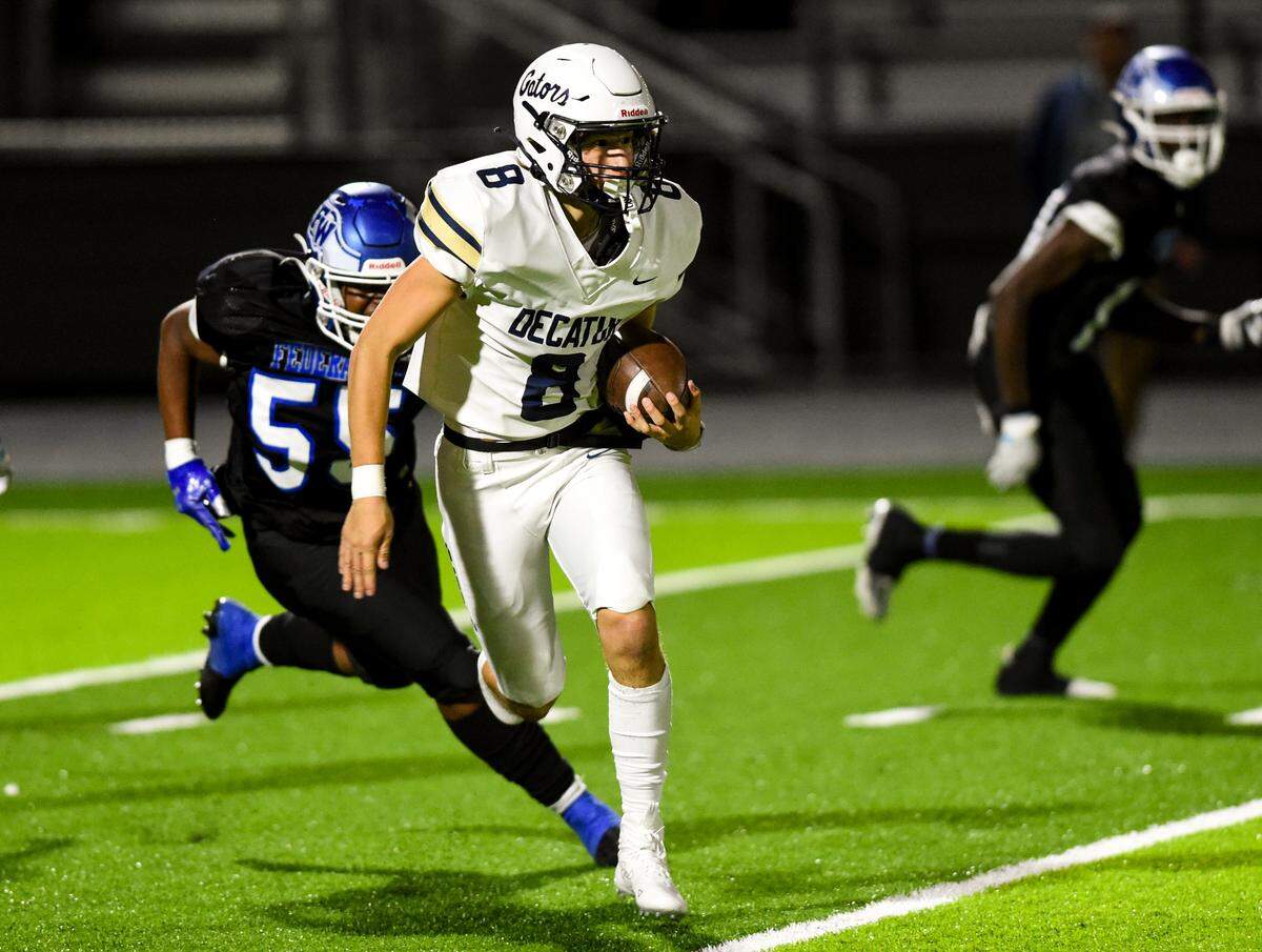 Decatur’s Spencer Holloway (8) scrambles on the run against the Federal Way Eagles during the first half of the game at Federal Way Memorial Stadium, Thursday, Oct. 26, 2023, in Federal Way, Wash.
