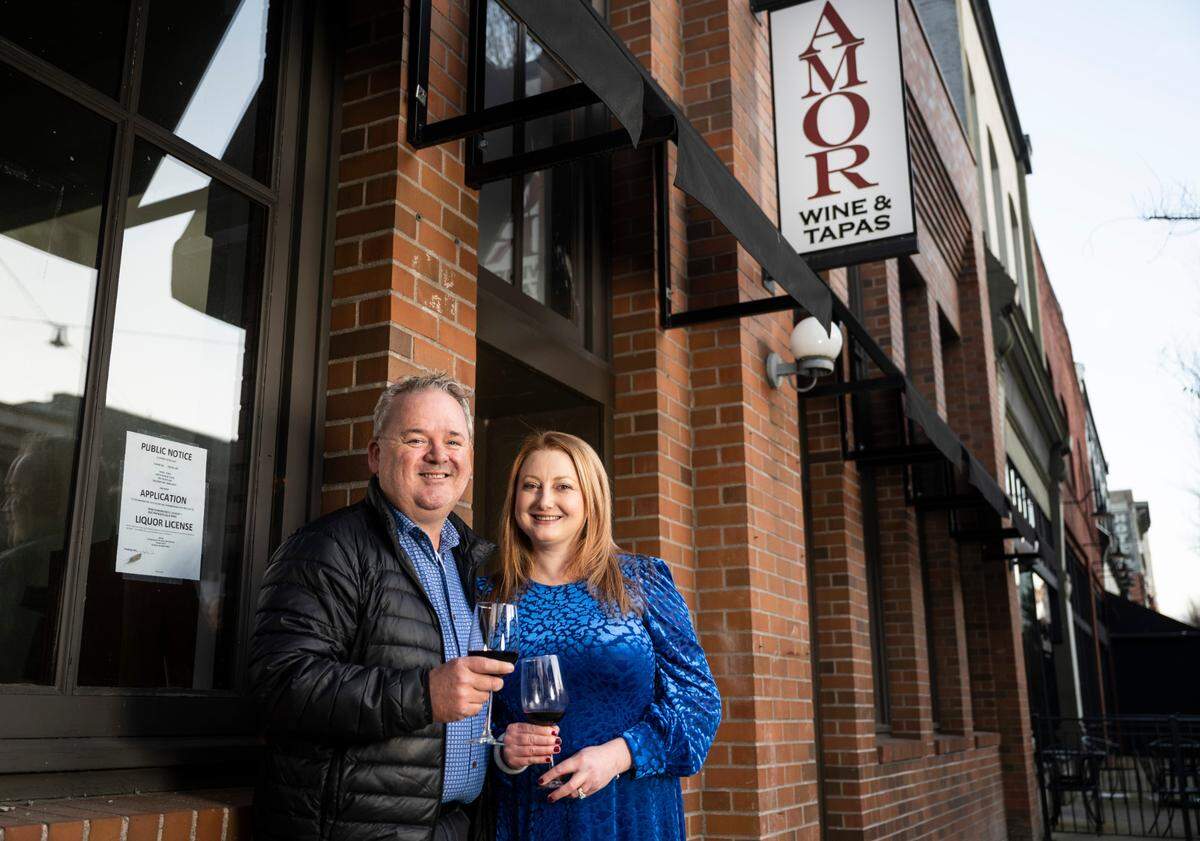 Amor Wine & Tapas co-owners Chris and Elizabeth Dasef pose for a portrait outside of the restaurant at 705 Pacific Ave. in downtown Tacoma on Feb. 14, 2023. The “sultry” restaurant and lounge will serve an eclectic menu of Mediterranean-inspired fare with a focus on food-friendly wines.