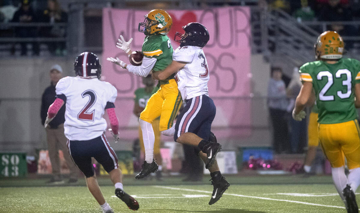 Tumwater defensive back Kai McLeod intercepts a pass in front of Black Hills running back Johnnie Stallings during Friday night’s Pioneer Bowl crosstown rivalry football game at Tumwater District Stadium in Tumwater, Washington, on Oct. 28, 2022.