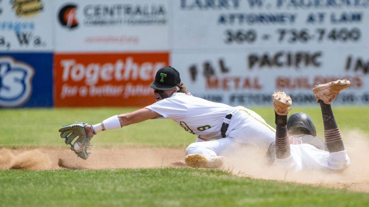 Tumwater shortstop Eddie Marson makes a diving grab on a wild throw to second as Grandview’s Carlos Guillen slides safely into the bag during the Trenton the first inning of a 2A State baseball opening round game at Wheeler Field in Centralia, Wash., on May 20, 2023.