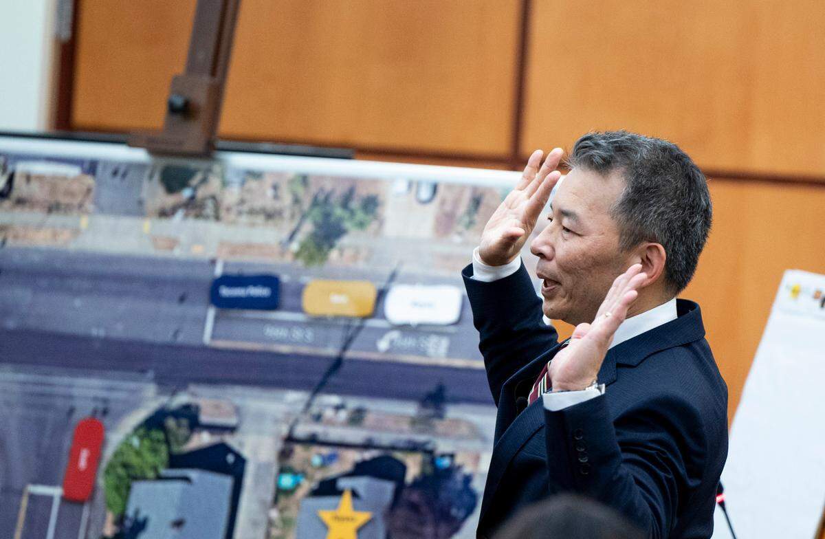 During his opening statement, assistant state attorney general Kent Liu demonstrates how Manuel Ellis raised his hands during a deadly encounter with Tacoma police in March 2020.