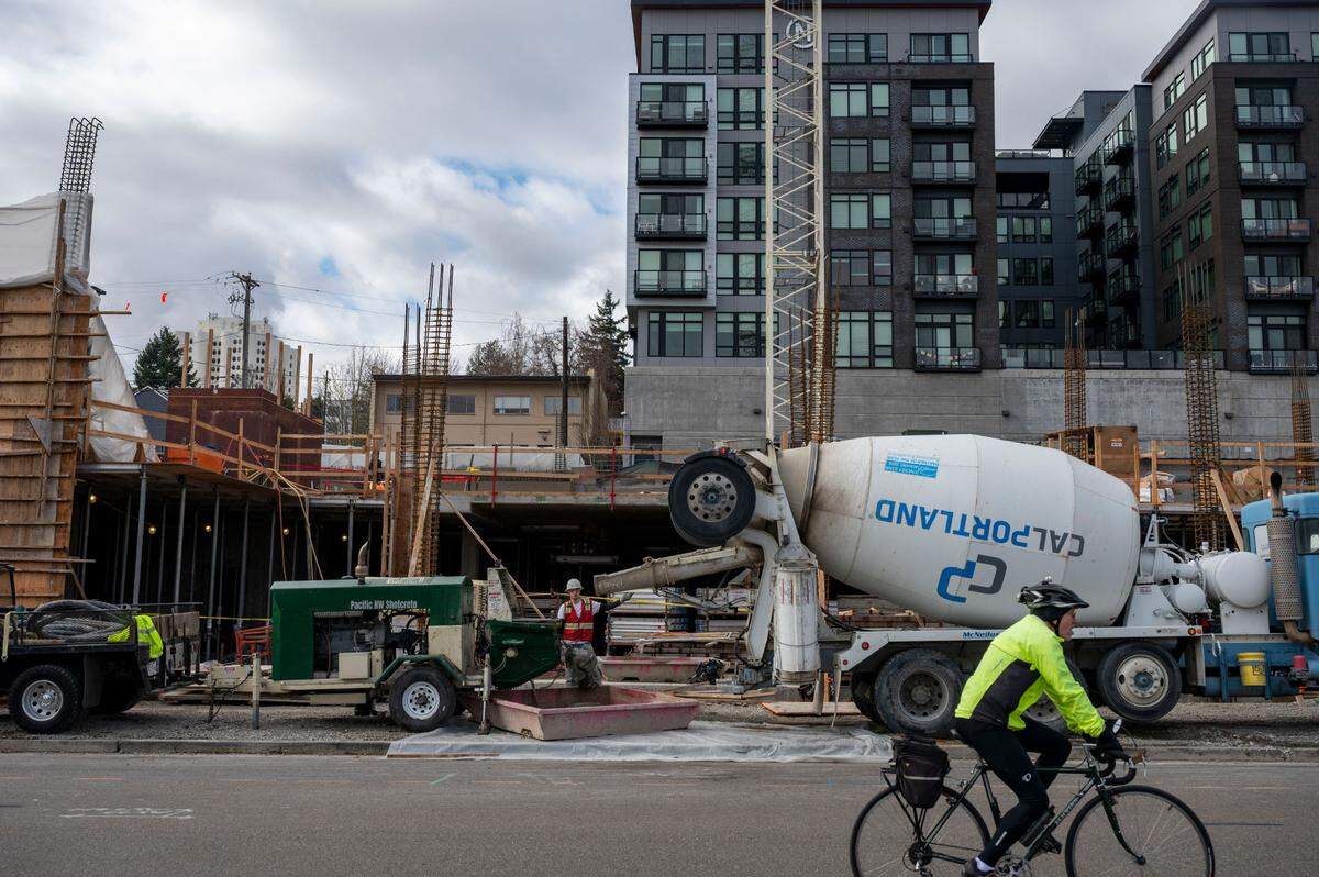 A cyclist pedals down Fawcett Avenue where construction on Rook, an apartment complex featuring 294 units at market rate and 74 units at affordable rates, continues just east of The Napoleon Apartments along Tacoma Avenue South in downtown Tacoma on Feb. 16, 2022.