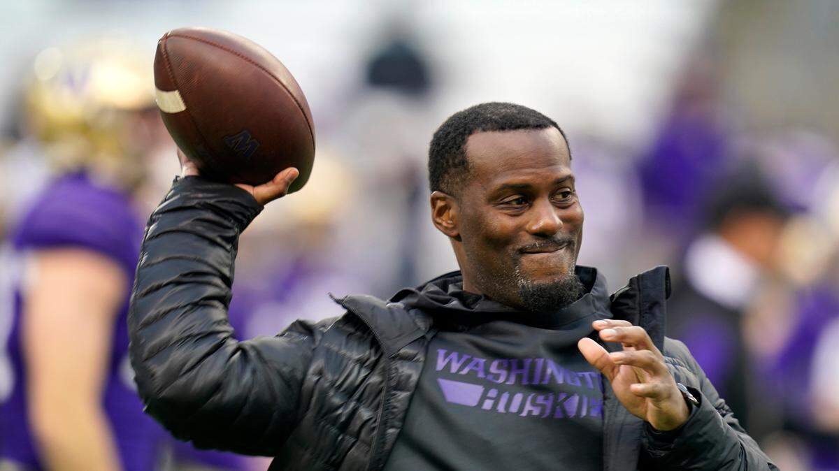 Washington assistant coach Junior Adams tosses a ball to players before an NCAA college football game against Arizona State Saturday, Nov. 13, 2021, in Seattle. (AP Photo/Elaine Thompson)