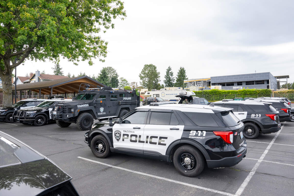 More than a dozen police vehicles sat parked in parking lot of The Church of Jesus Christ of Latter-day Saints along South 12th and South Pearl streets after police officers were seen staging for an arrest operation in the area on Thursday, June 12, 2025, in Tacoma, Wash.