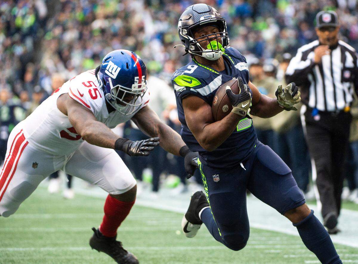 Seattle Seahawks running back Kenneth Walker III (9) runs past New York Giants linebacker Jihad Ward (55) to score a touchdown in the fourth quarter of an NFL game at Lumen Field in Seattle, Wash. on Oct. 30, 2022. The Seahawks defeated the Giants 27-13.