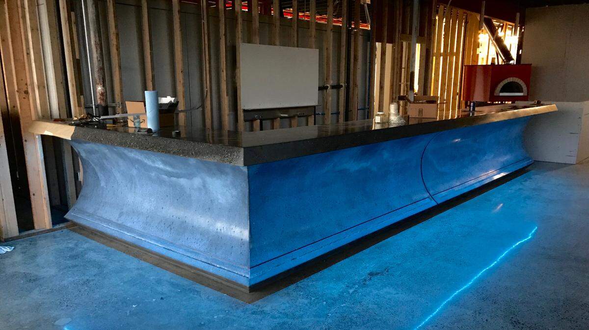 The custom concrete bar at Sig Brewing leads into an open kitchen with a pizza oven, and behind it the brewing production area. Sig is already distributing its beers around Tacoma, but the restaurant and taproom hopes for a spring opening.