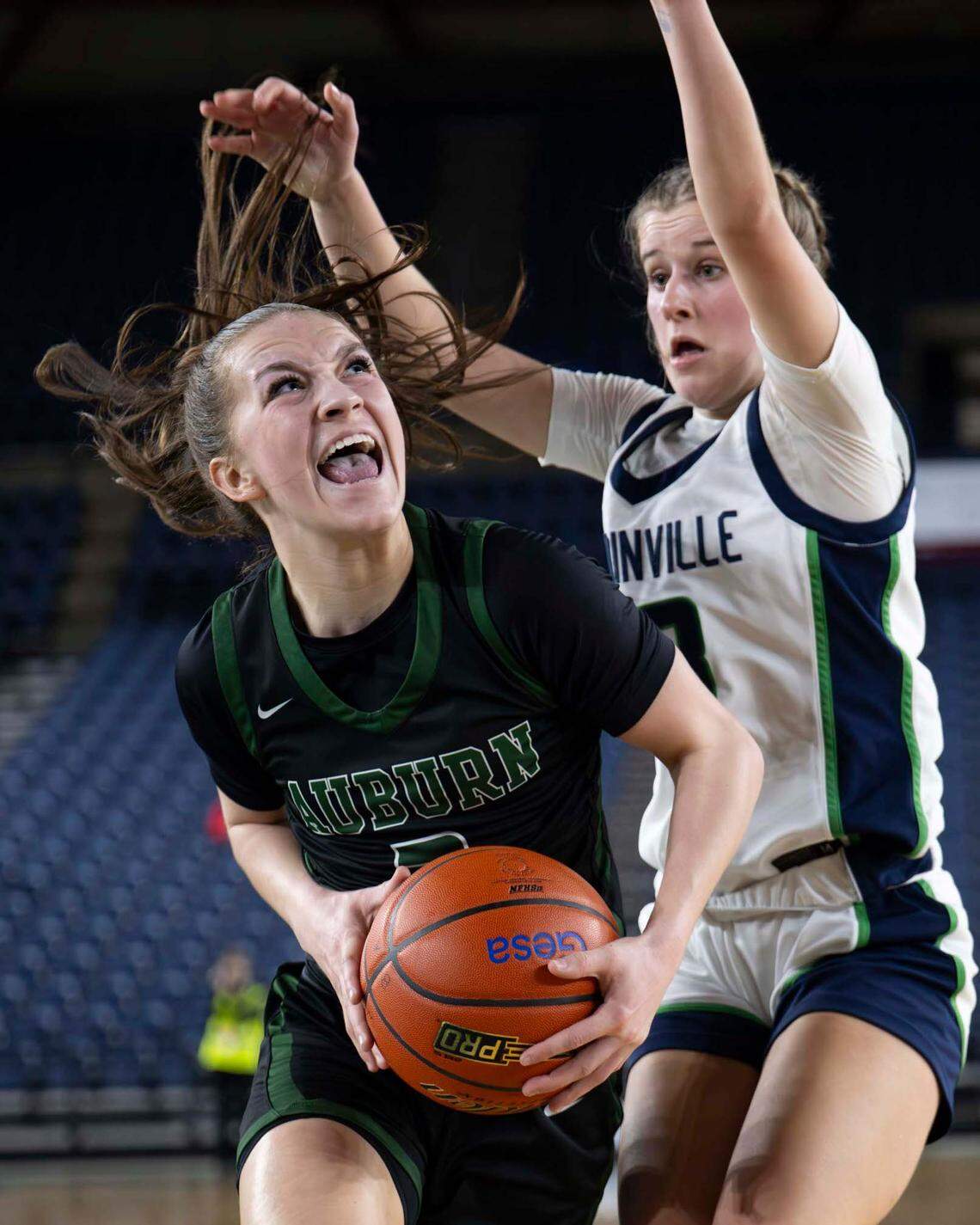 Auburn’s Avery Hansen (3) drives to the basket as Woodinville guard Sam Harris (23) defends during the first half of a Class 3A state basketball tournament first-round game at the Tacoma Dome on Thursday, March 6, 2025, in Tacoma.