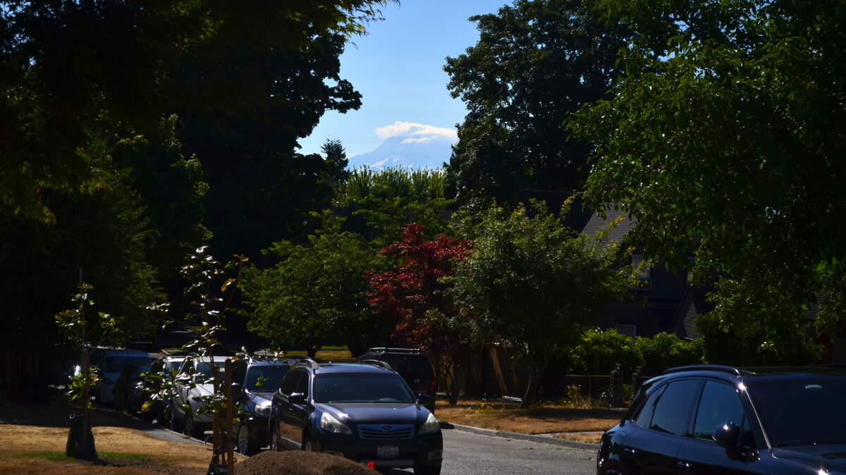 Mount Rainier peaks through clouds in Tacoma on Saturday, July 22, 2023. National Weather Service forecasters say slightly below-normal temperatures are expected to close out the month.