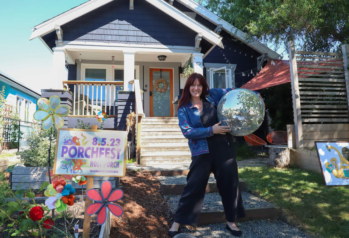 Anna Lee poses in front of her home, decorated for Porchfest, on Wednesday, Aug. 2. 2023.