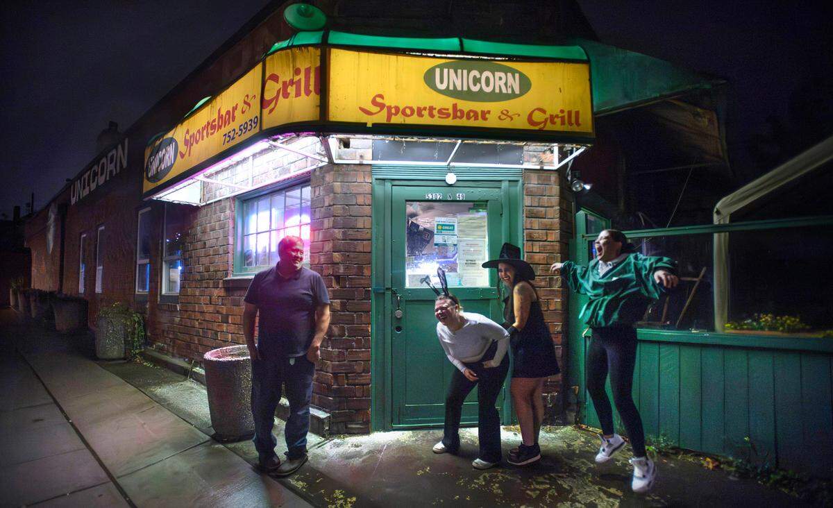 Doorman David Cason talks with Keri Hollenbeck (from left), Tilly Villanueva and Desiree Godwin outside of the Unicorn Sports Bar & Grill in Ruston, Washington, Friday, Oct. 25, 2024.