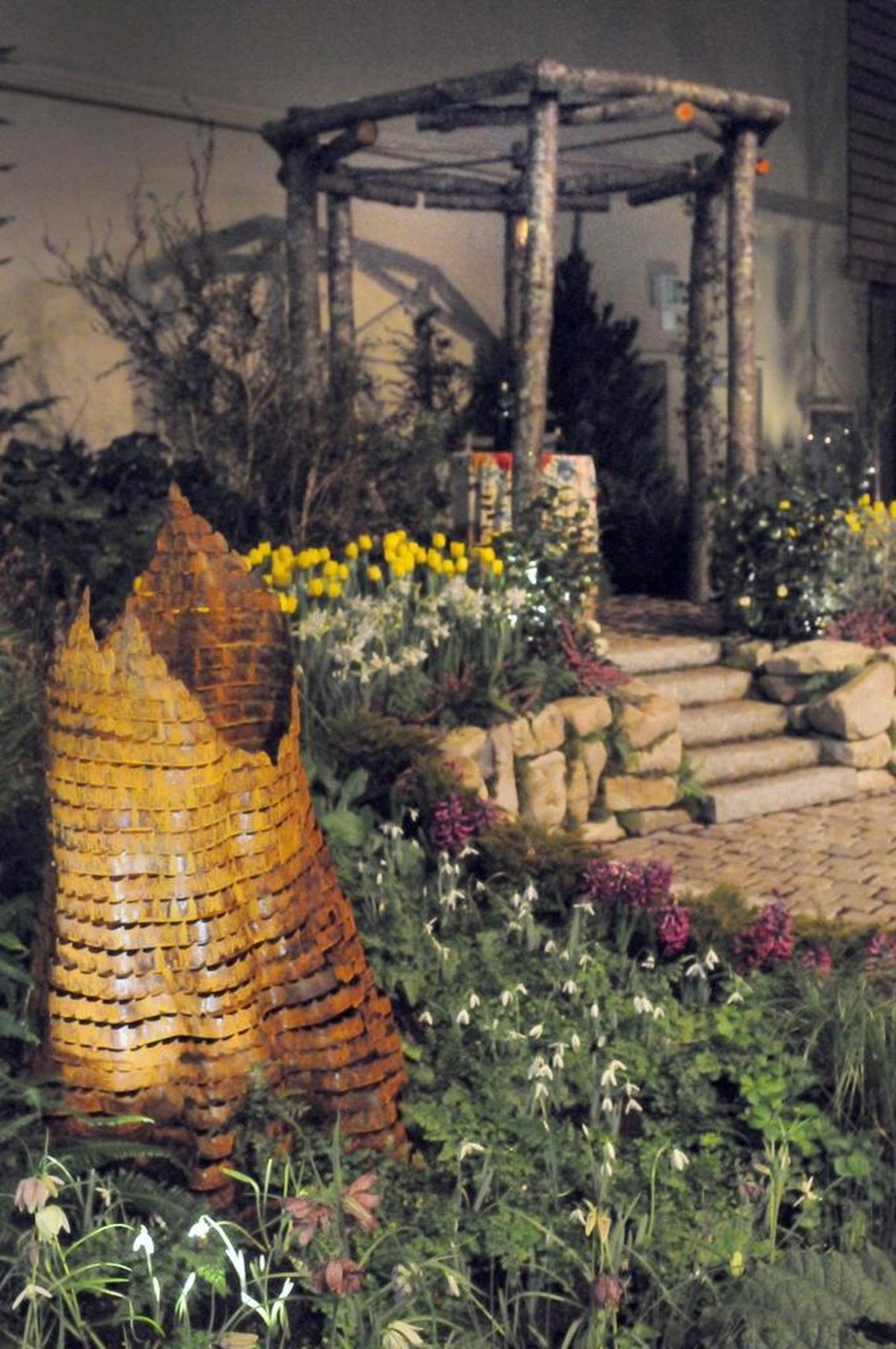 A metal stump sculpture made from band saw blades and a pergola made from alder logs were the focal points of a display garden at a past Northwest Flower and Garden Show.